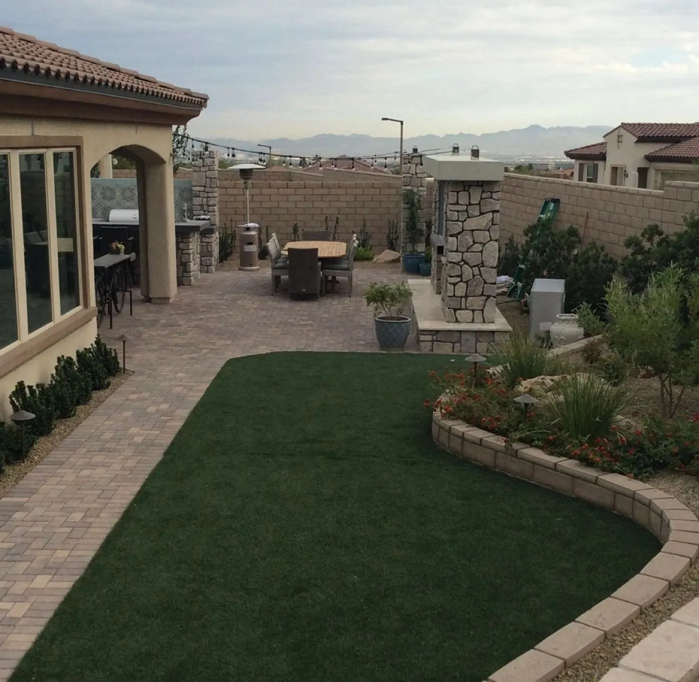 Backyard pavers with turf and block walls
