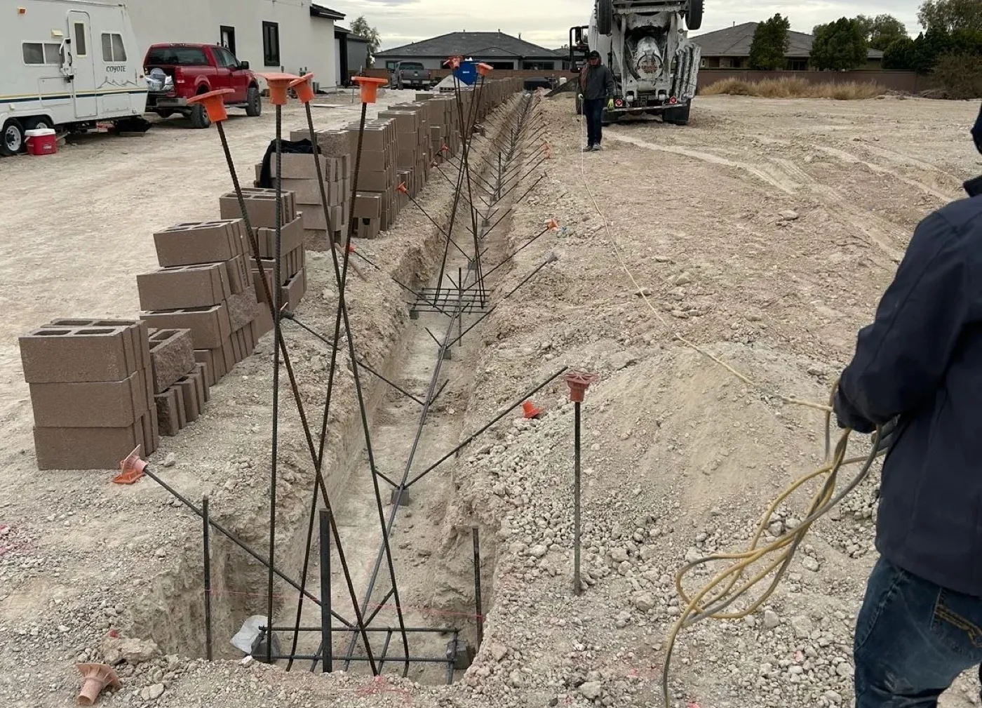 Footing trench with rebar cages and stacked block ready for a block wall build in Las Vegas