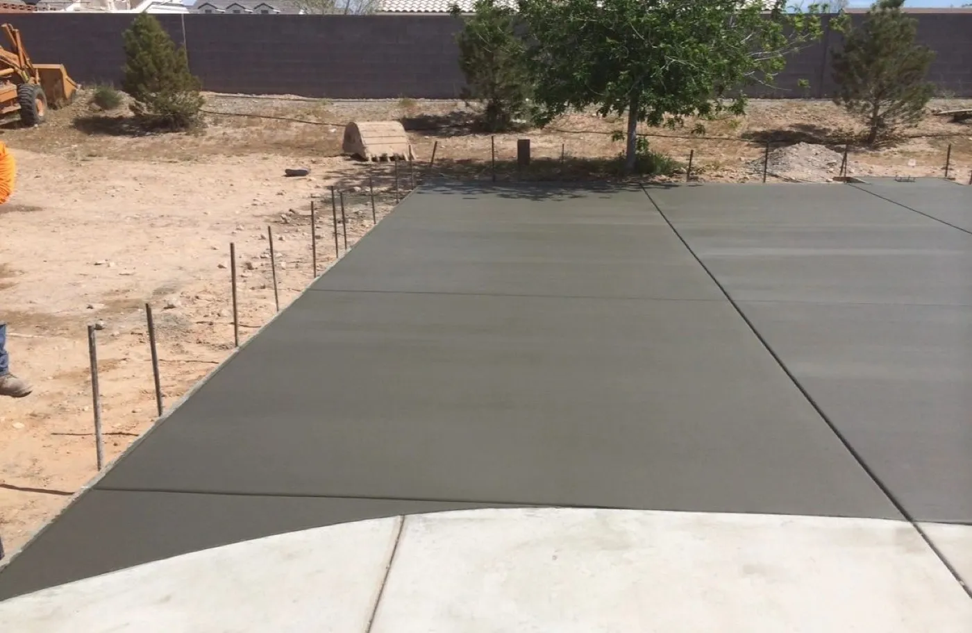 Freshly poured concrete slab with tooled control joints across a new Las Vegas backyard lot