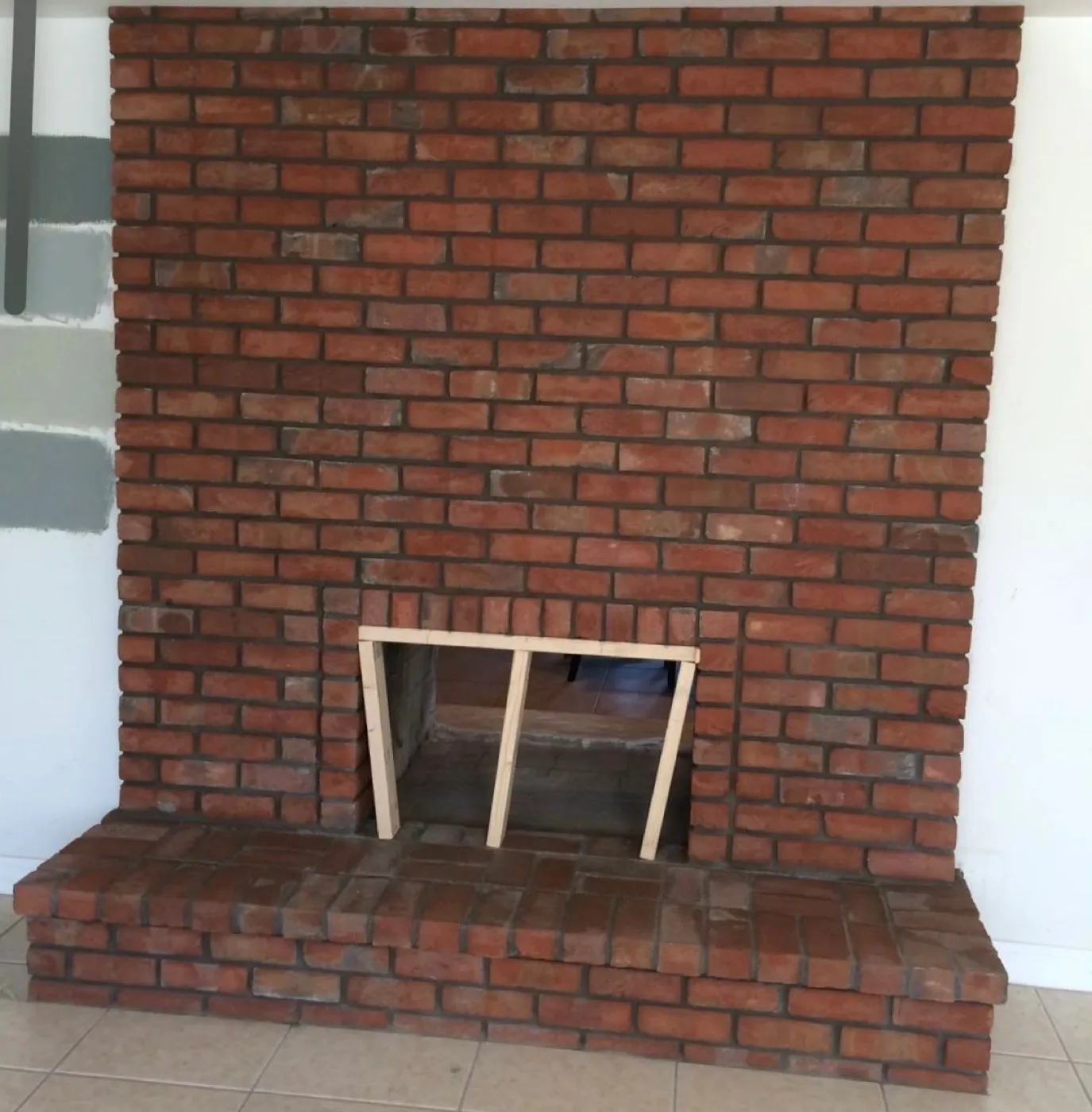 Finished red brick fireplace with a raised brick hearth inside a Las Vegas home